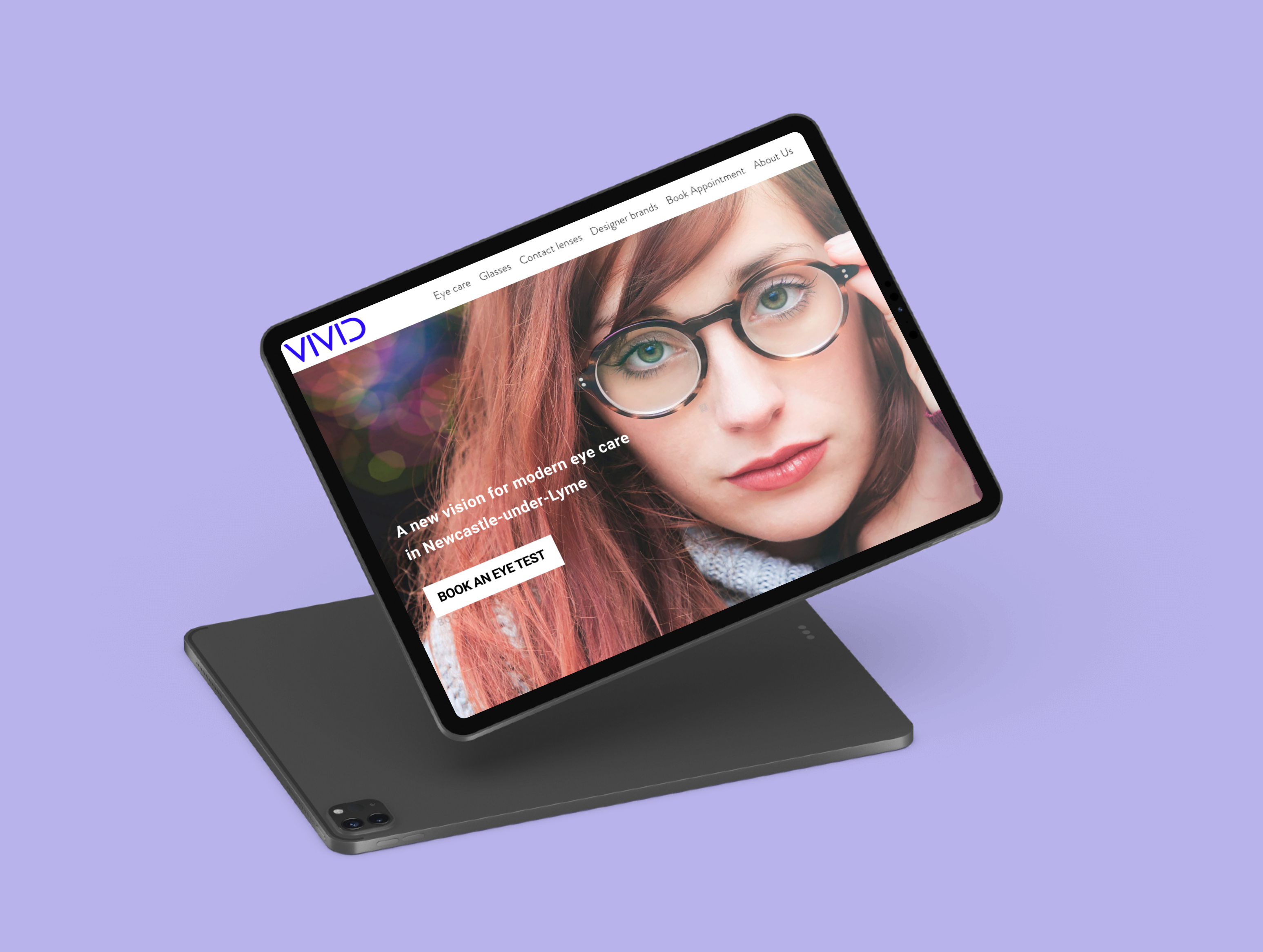 Tablet displaying a website homepage with a close-up image of a woman wearing glasses and text about eye care in Newcastle-under-Lyme.